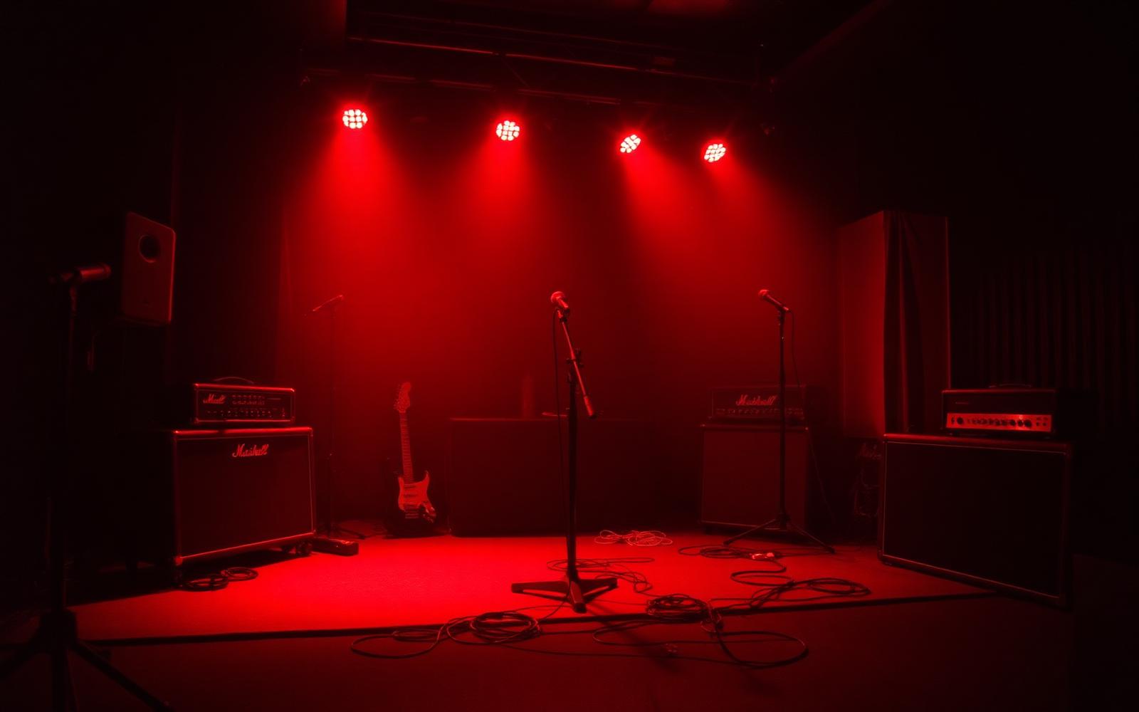 Palco vazio iluminado em vermelho antes do show da REDFLY